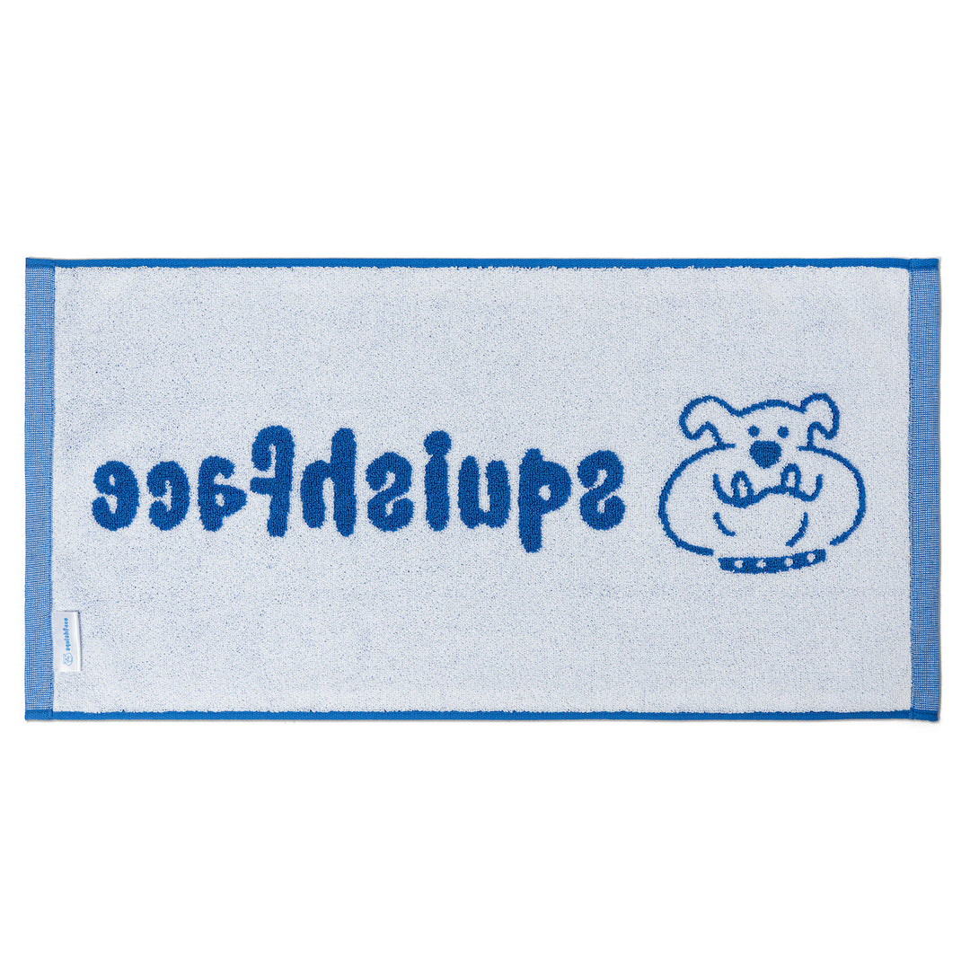 White towel with blue border and text, featuring a cartoon dog illustration on a white background.